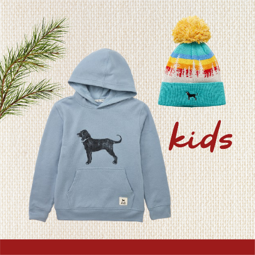 Children's blue hoodie with dog graphic and colorful beanie on a textured beige background