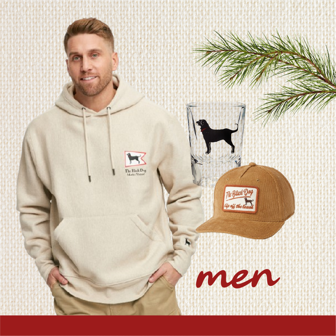 Man wearing a beige hoodie with a logo, glass with the black dog, and brown cap on a textured background.